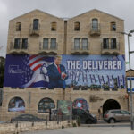A photograph shows a banner depicting US President Donald Trump with the slogan "The Deliverer" in Jerusalem on April 20, 2026.